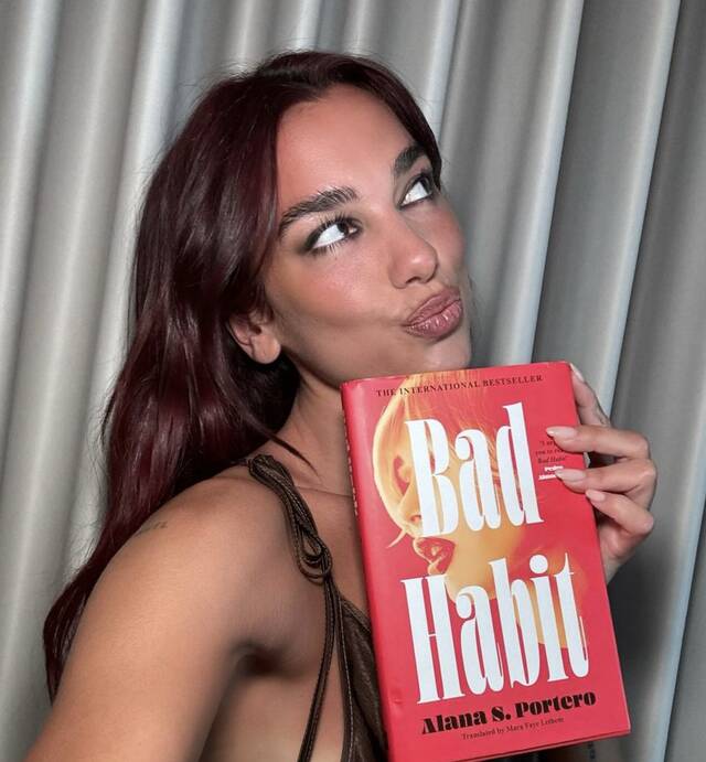 Dua Lipa con el libro «Bad Habit» de Alana S Portero 