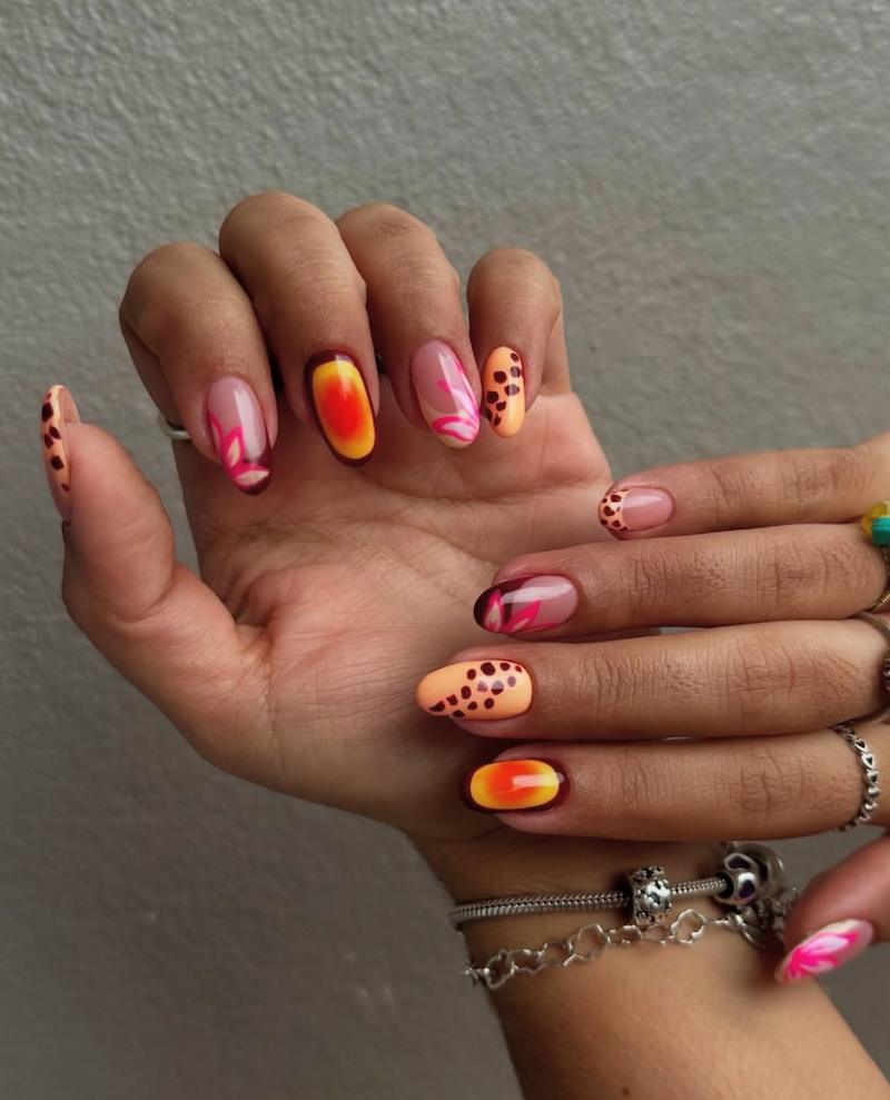 Diseño de uñas color naranja mango para el verano de estilo tropical.