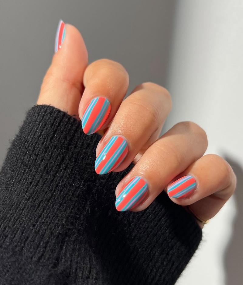 Uñas en rayas naranja y azul
