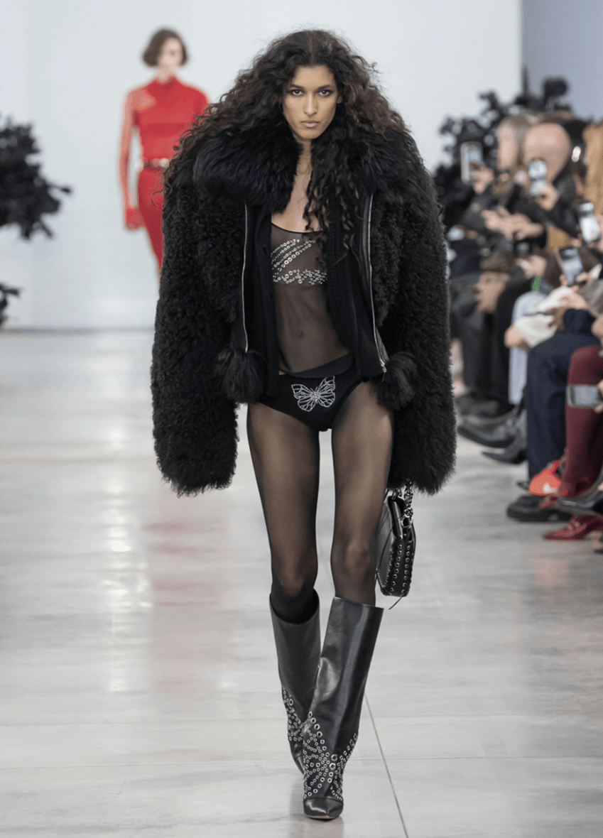 Modelo desfilando con chaqueta de hombreras.