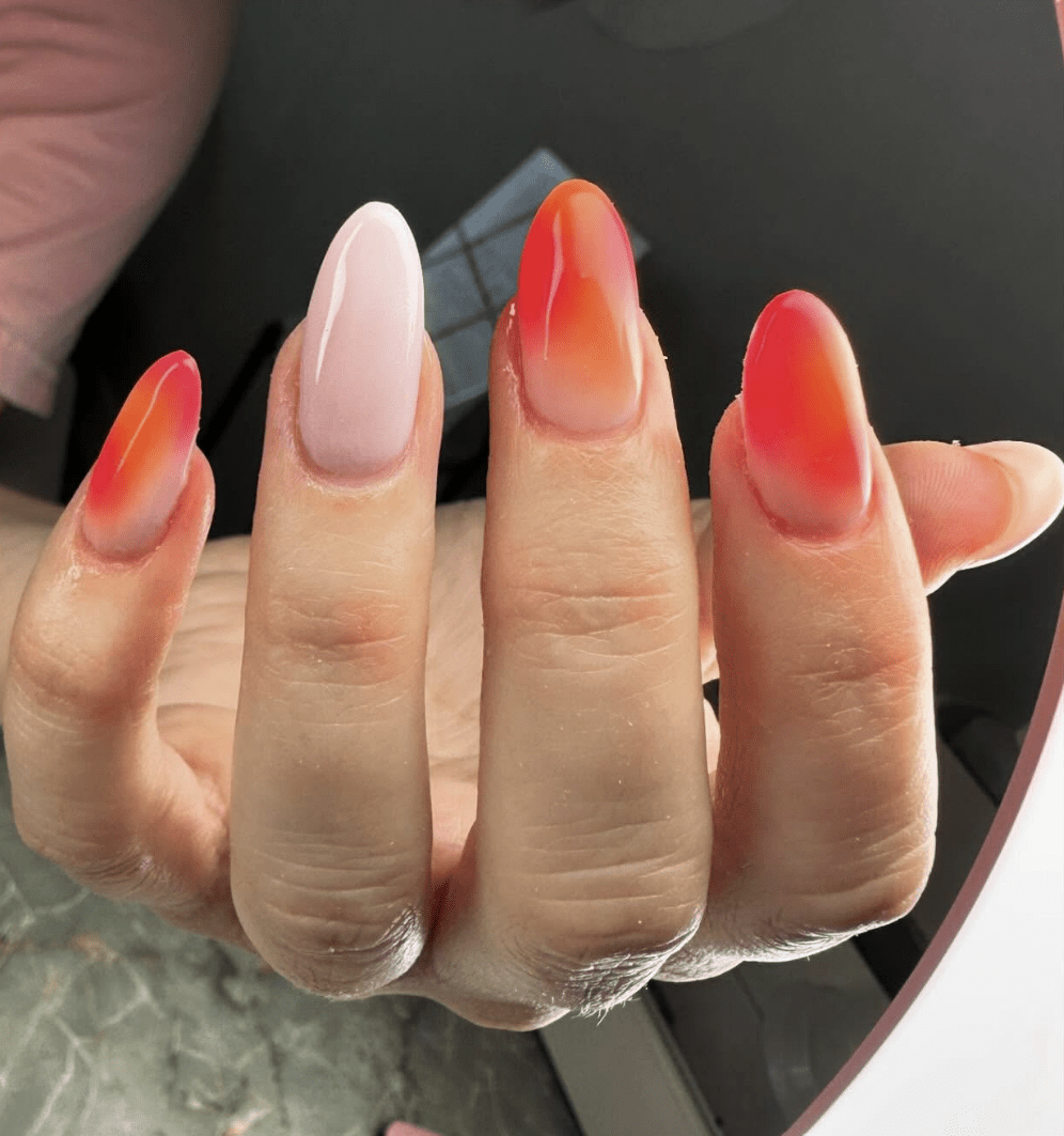 Uñas con diseño shelter en tonos nude, rojo fresa y naranja.