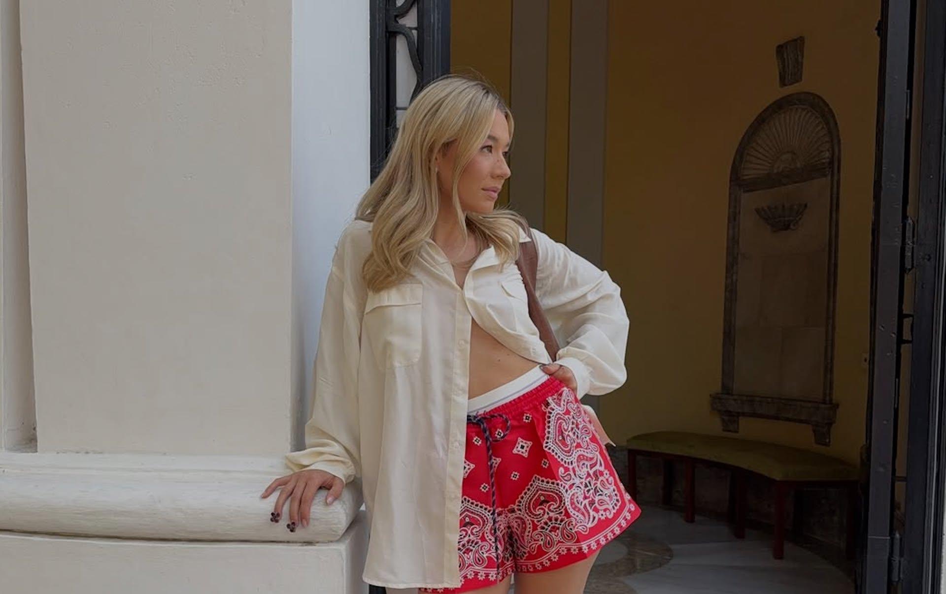 Look veraniego con shorts rojos estampados paisley o bandana print combinados con camisa fluida y sandalias minimalistas, una de las formas más virales de llevar esta tendencia en primavera-verano 2026. Imagen: @marianadiezmoliner