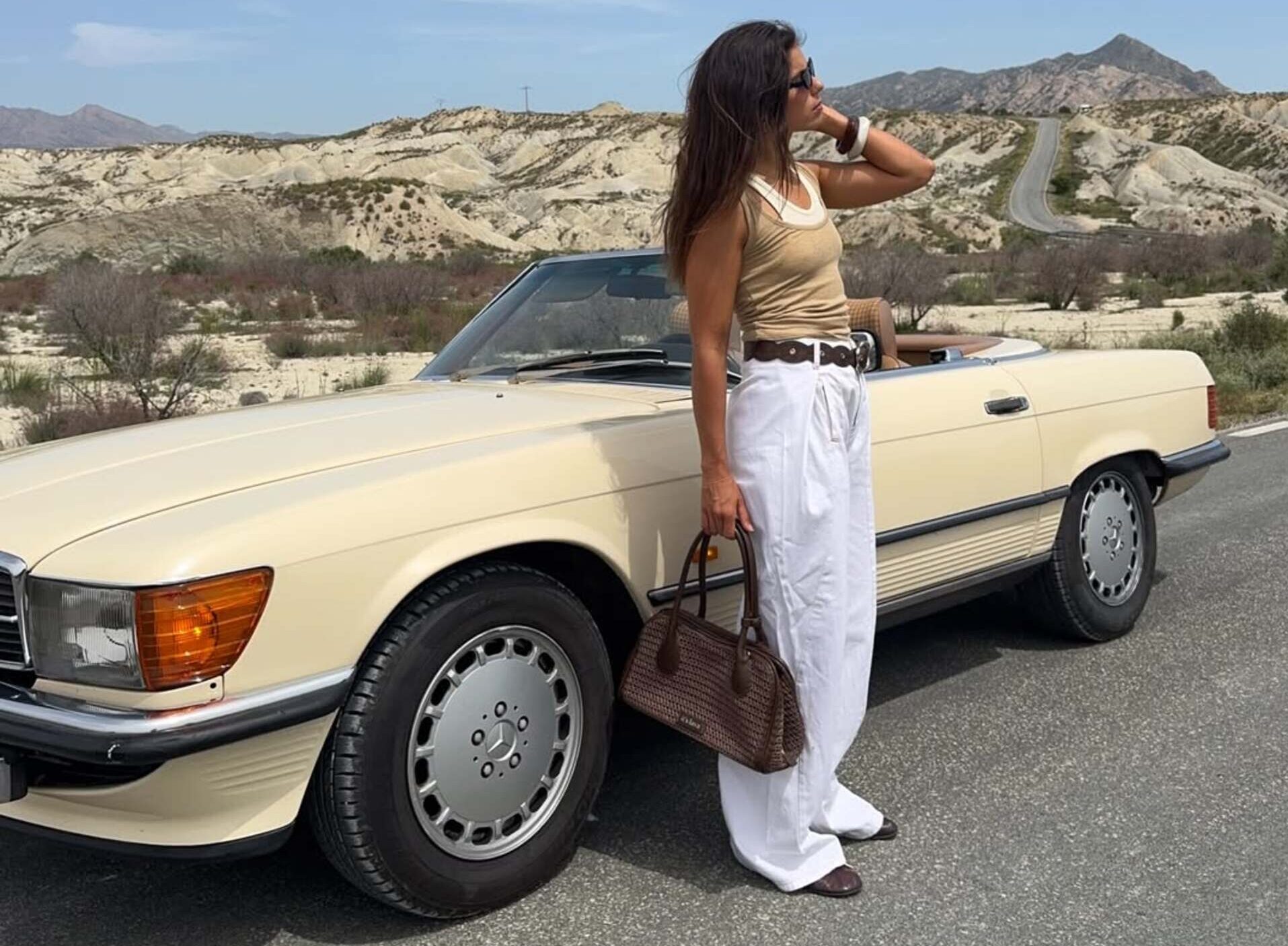 Sara Baceiredo posa junto a un coche descapotable durante una ruta por Murcia con un look cómodo y perfecto para viajar ligero este verano. Imagen: @sarabace