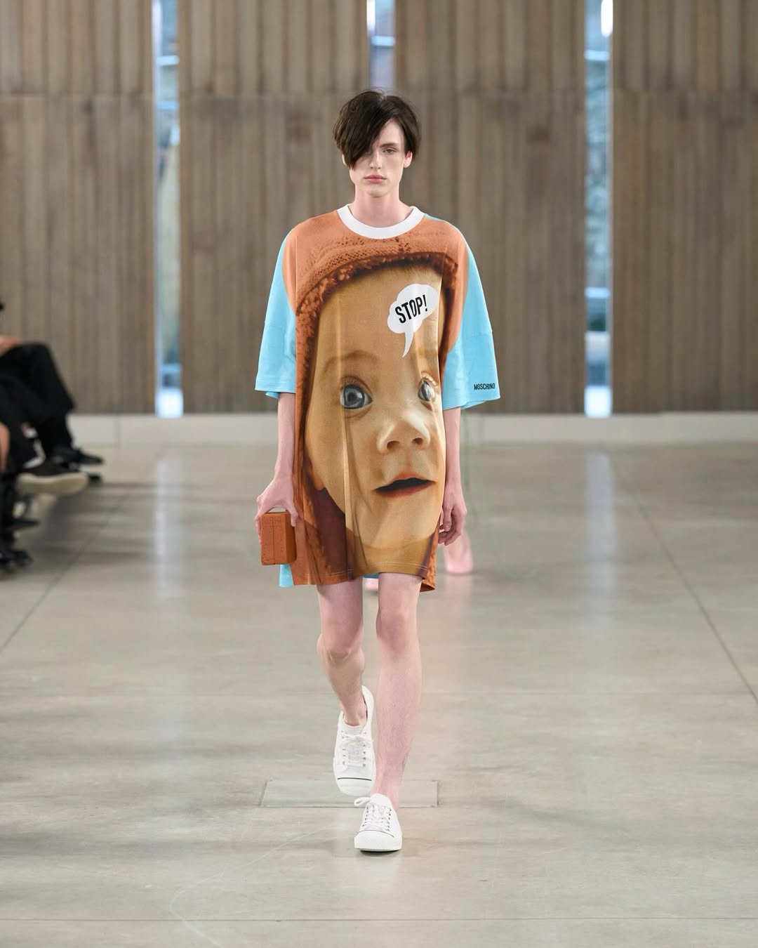 Modelo desfila para Moschino con un vestido estampado con el rostro de un bebé y un bocadillo con la palabra «Stop!»