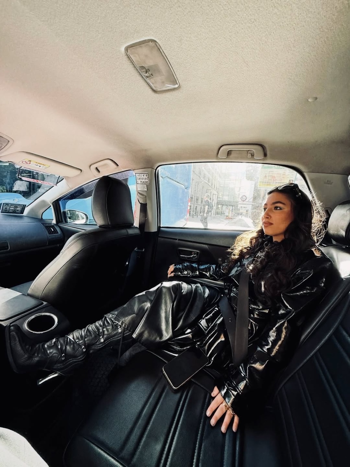 María José Llergo sentada en un coche con look negro brillante durante la era de «El Juego»
