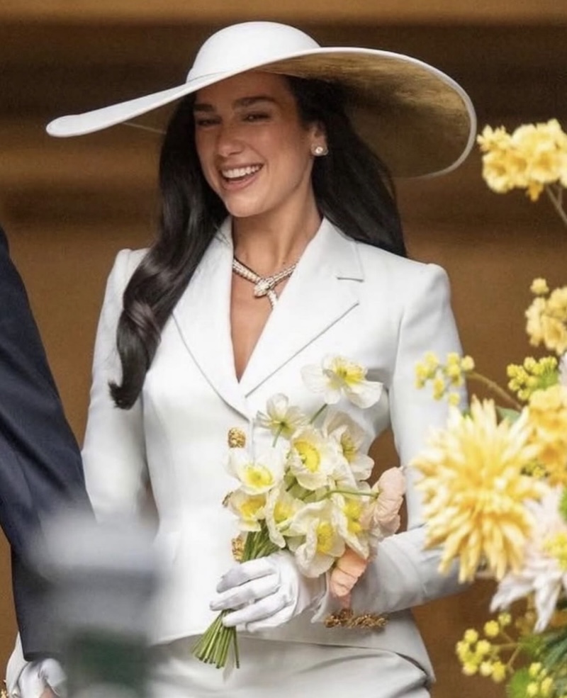 Dua Lipa con un estilismo de chaqueta y falda en color blanco firmado por Schiaparelli acompañado por un sombrero de ala ancha de Stephen Jones. Imagen: @stephenjonesmillinery