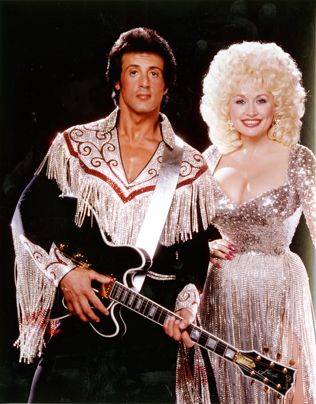 Dolly Parton junto a Sylvester Stallone en «Rhinestone» (1984), una de las películas que formaron parte de su trayectoria como actriz en Hollywood