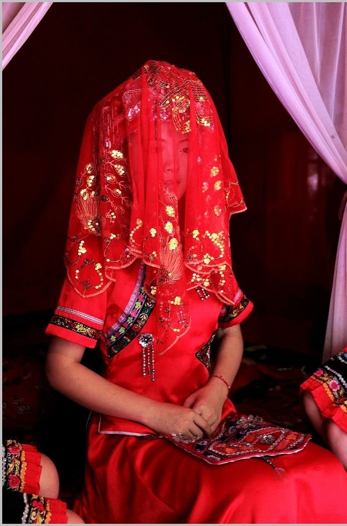Atuendo de novia tradicional de color rojo y un velo bordado