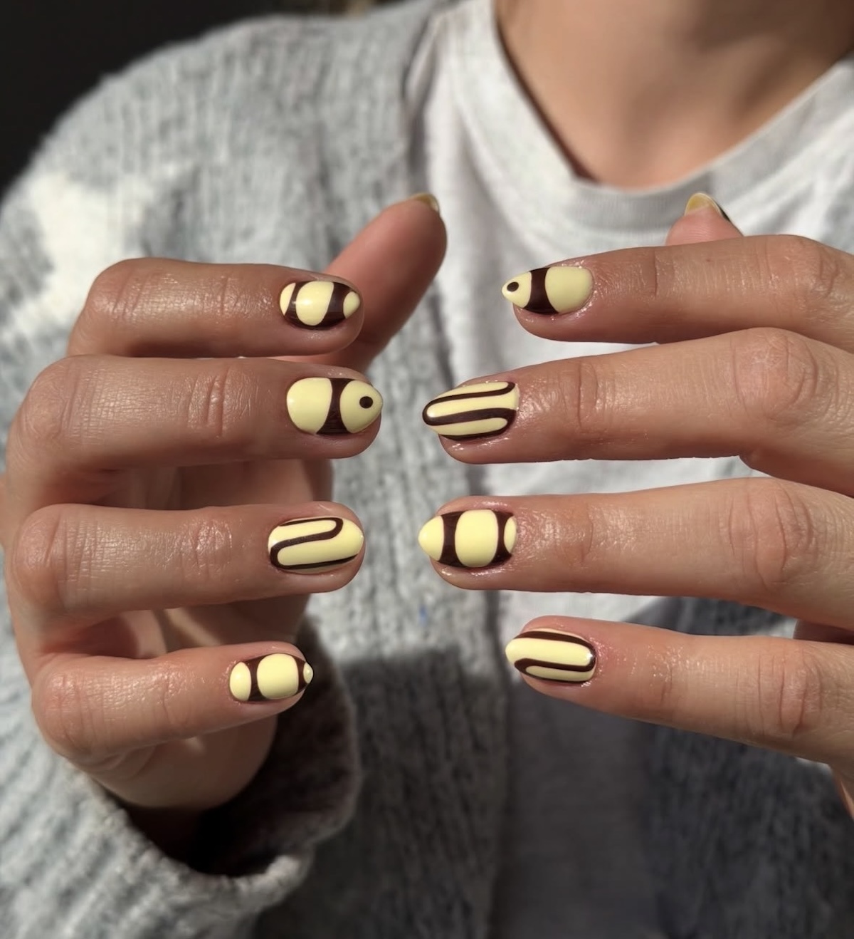 Diseño de uñas en marrón y amarillo. Imagen: @nailsocietyy