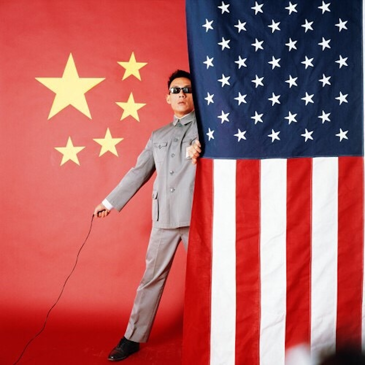 obra fotográfica East Meets West Manifesto (1983) del artista y fotógrafo sino-estadounidense Tseng Kwong Chi, conocida por su serie de autorretratos satíricos donde cuestiona la identidad y la geopolítica vistiendo un traje de Mao. 