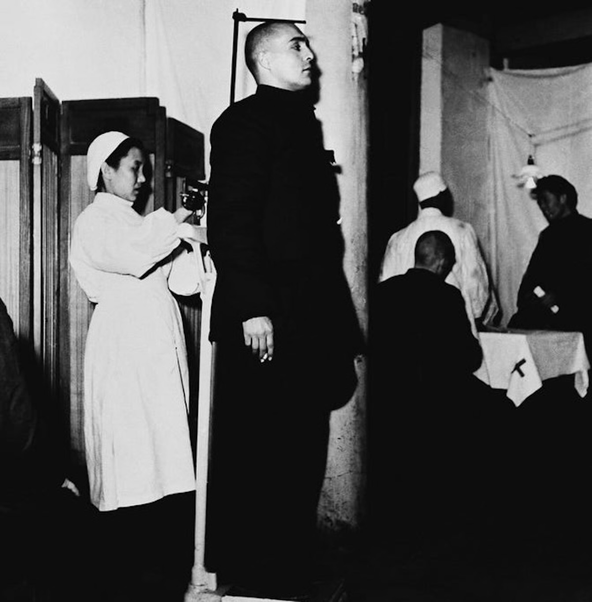 La imagen muestra al prisionero estadounidense Richard J. Fecteau mientras es medido por una enfermera durante su cautiverio en China el 21 de enero de 1955