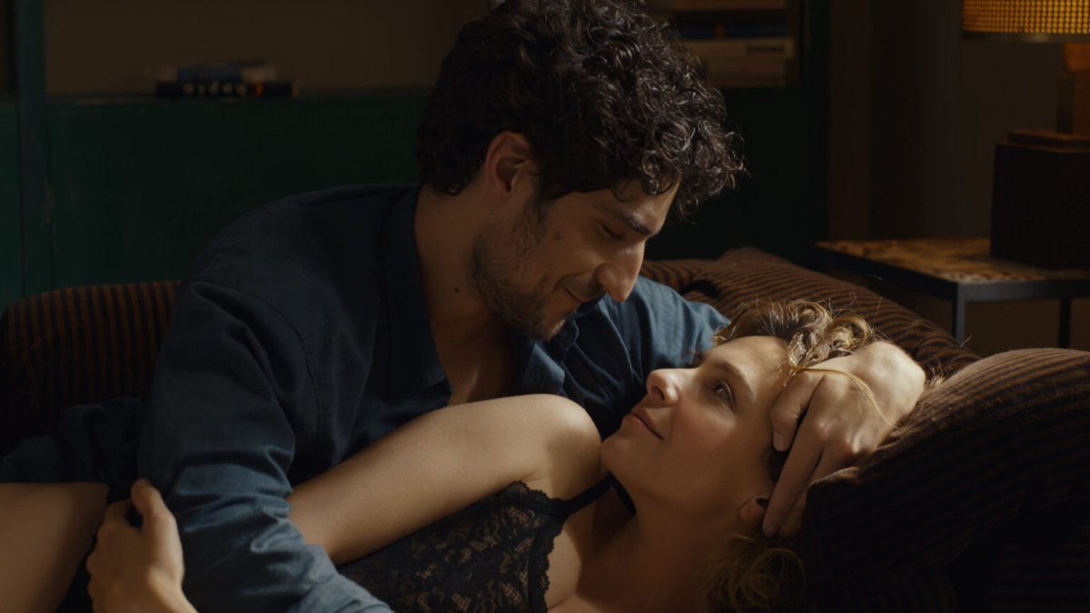 Los protagonistas se miran con complicidad mientras permanecen recostados en un sofá o una cama, en una escena de la película «Succederà Questa Notte», dirigida por Nanni Moretti.