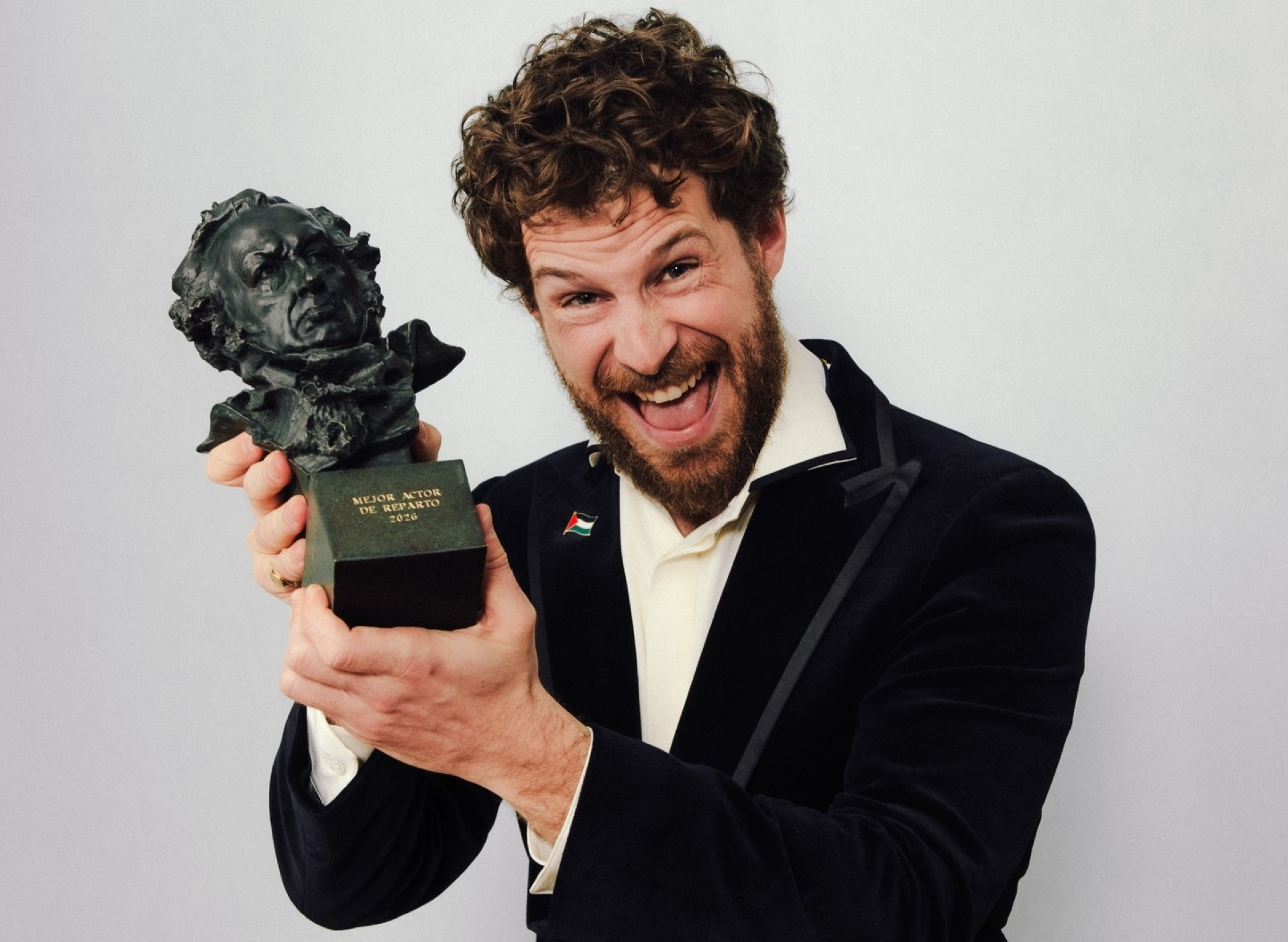 Álvaro Cervantes sonríe mientras sostiene la estatuilla del Goya a Mejor Actor de Reparto 2026