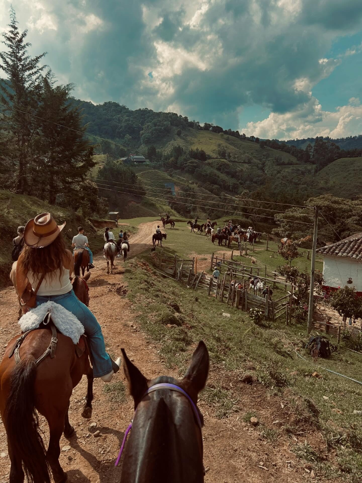 Paseo a caballo por un paisaje natural y montañoso, con varios jinetes disfrutando de la ruta al aire libre