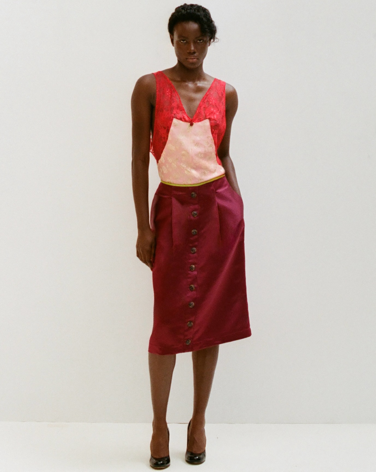 Janet luce el look 4 de la colección «In Lieu of Flowers» SS27 de Ewusie, formado por un top de encaje en contraste y una falda burdeos con botones frontales