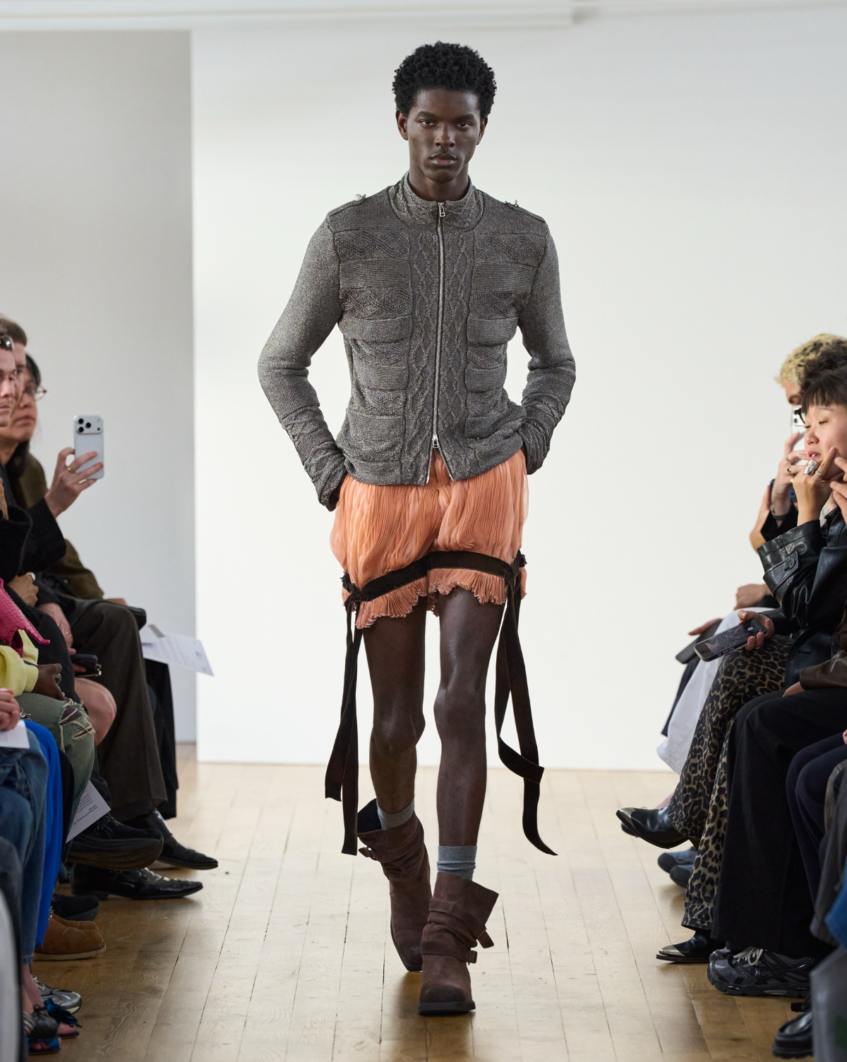Chaqueta gris de corte sastre sobre una camisa clara y un pantalón naranja de pierna amplia durante la presentación de la colección «Cygnet» SS27 de Oscar Ouyang en Londres