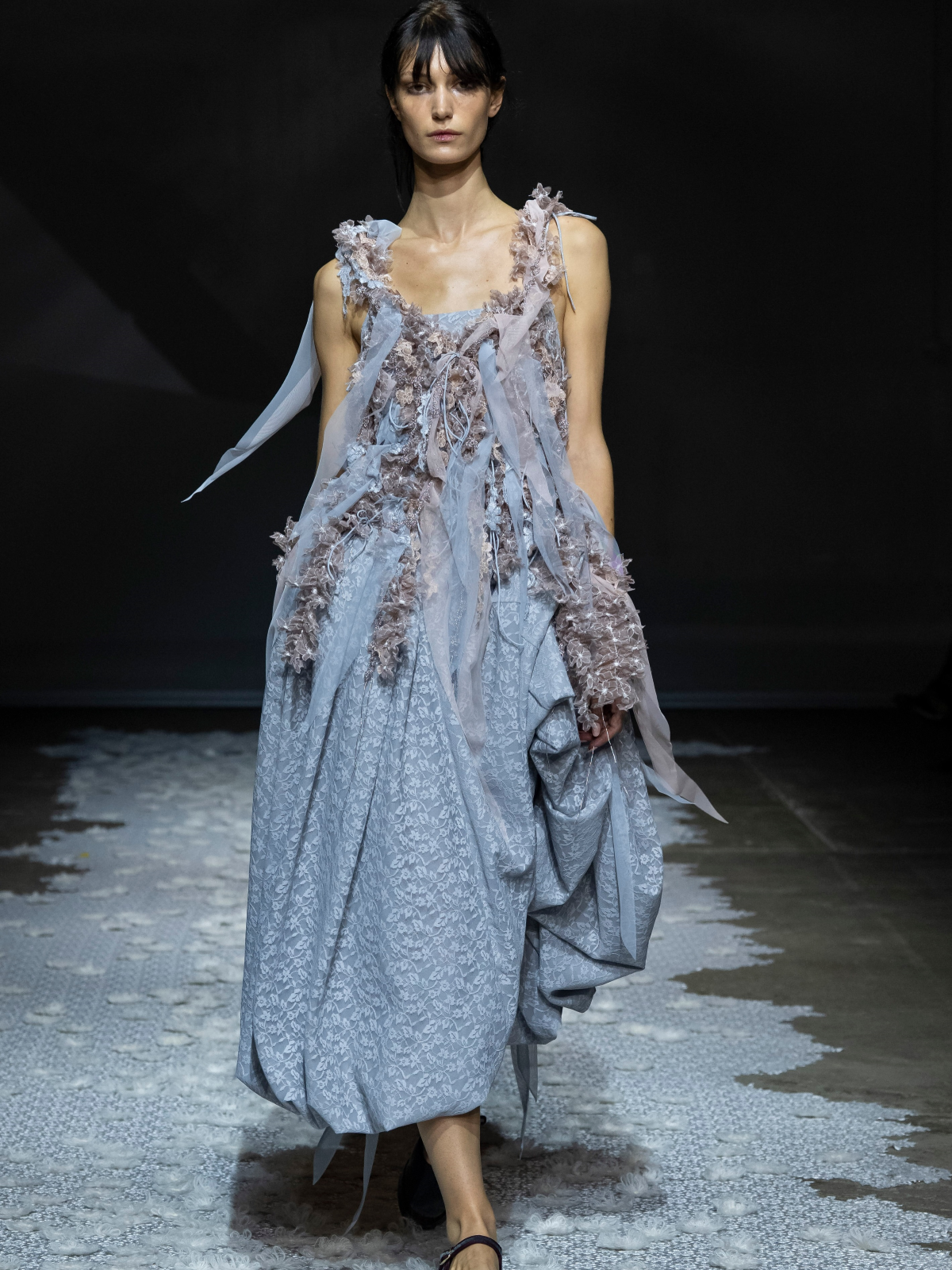Modelo luce un look azul de Pauline Dujancourt, formado por una silueta ligera y detalles de punto y textura, durante el desfile de la colección primavera-verano 2027 en la London Fashion Week