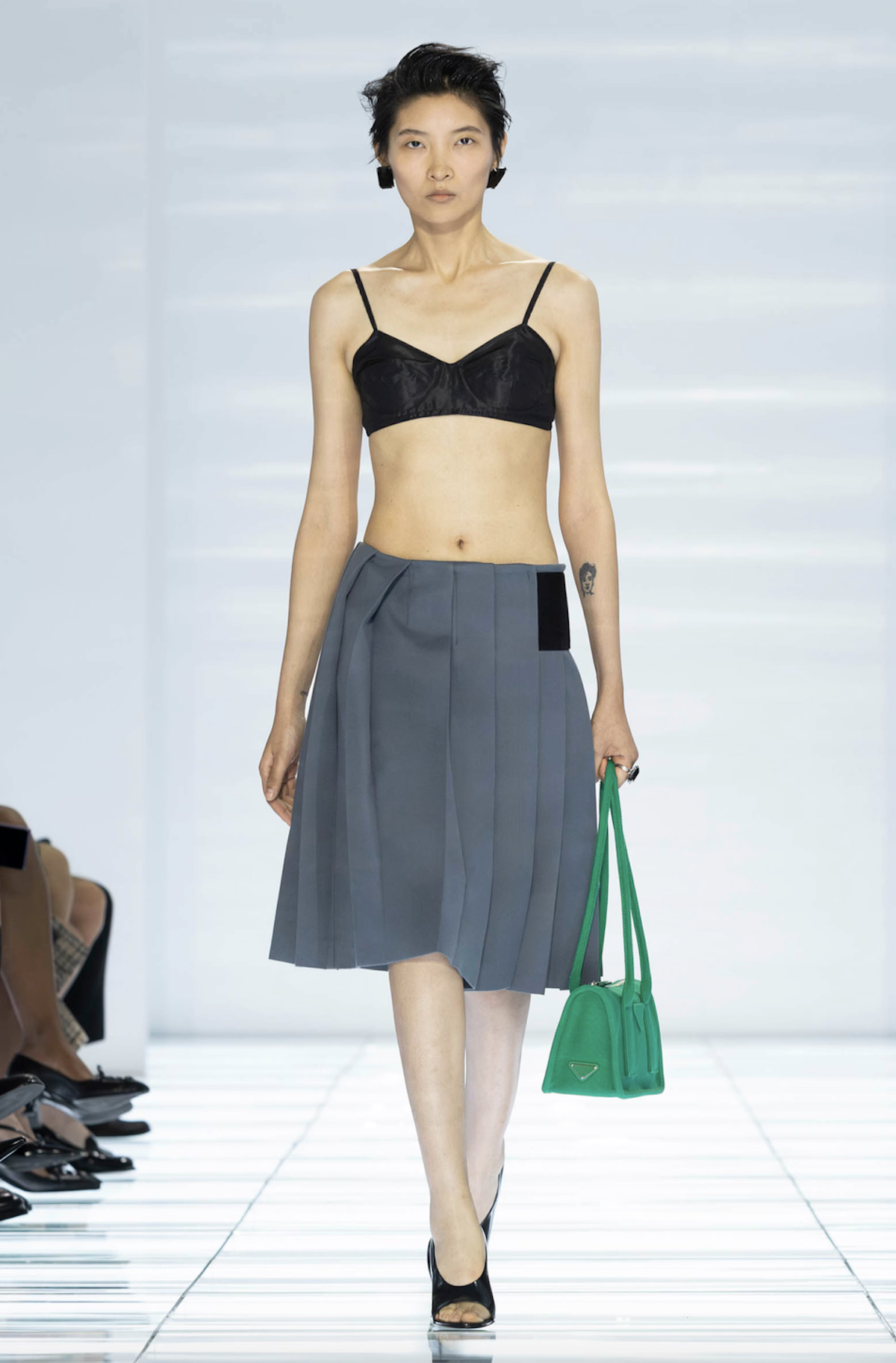 Estilismo de la colección SS27 de Prada formado por una falda gris y bralette