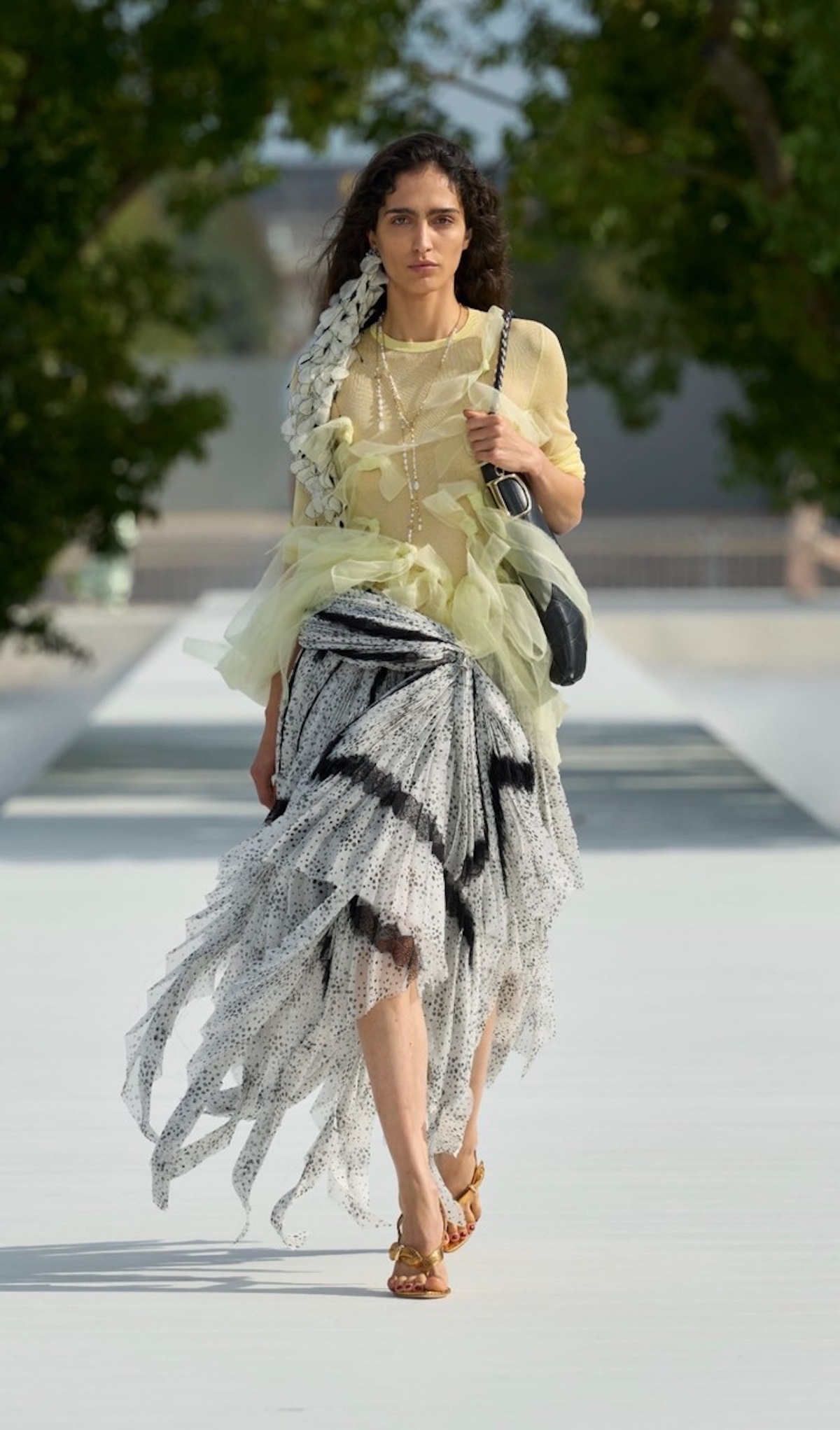 Transparencias, volantes y una falda de estampado gráfico protagonizan este look de Dior SS27 diseñado por Jonathan Anderson