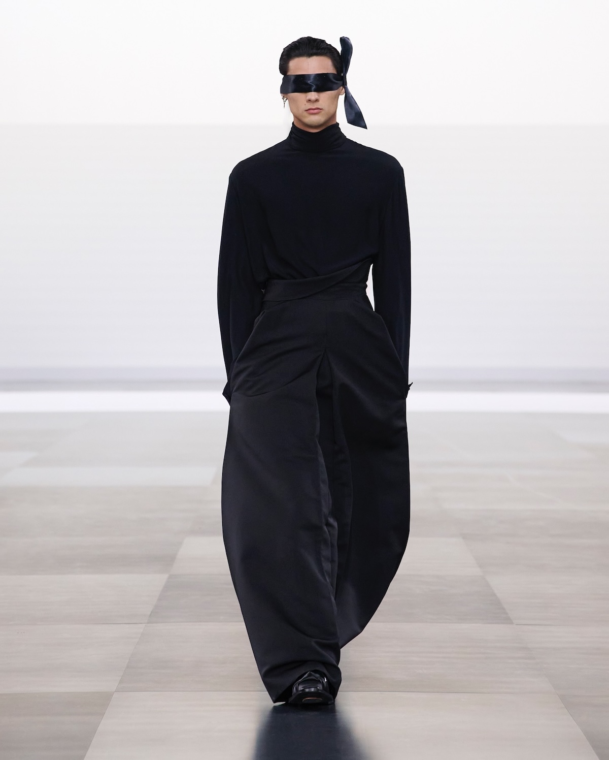 El modelo luce un conjunto monocromático en color negro de la colección Dior Men Invierno 2025-2026.