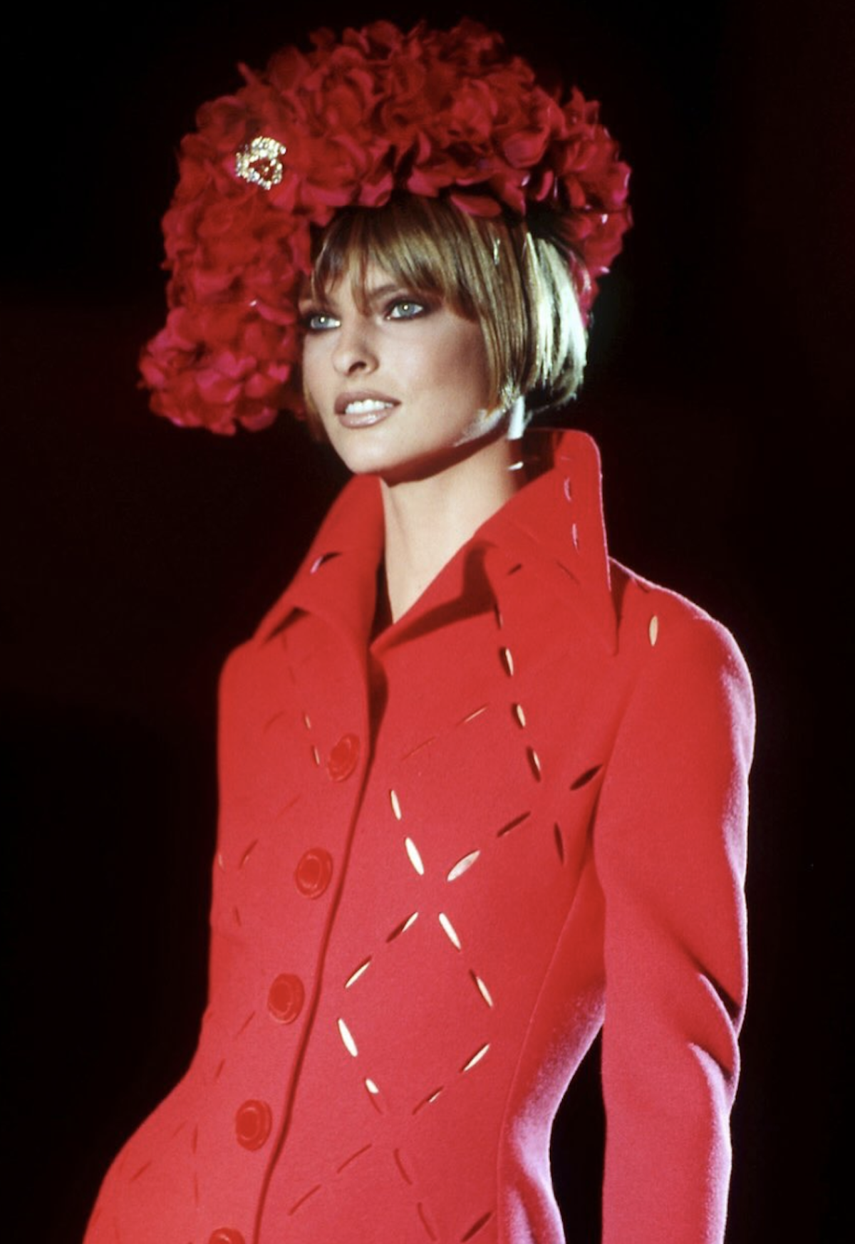 Linda Evangelista luce un diseño rojo con tocado floral en un desfile de Atelier Versace durante los años noventa, la época dorada de la alta costura de Gianni Versace. Imagen: @themuseofversace