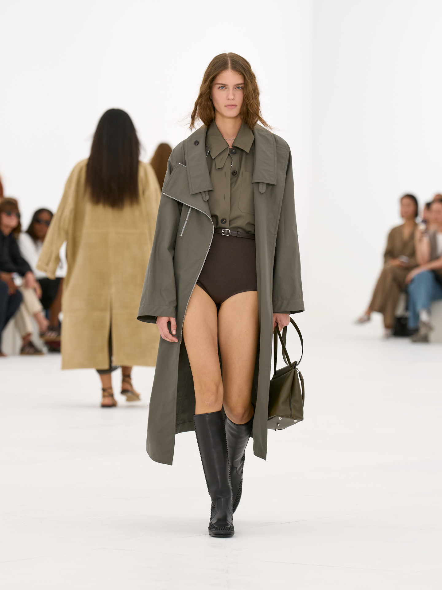 Abrigo verde oliva, body y botas altas en el desfile Hermès primavera-verano 2027