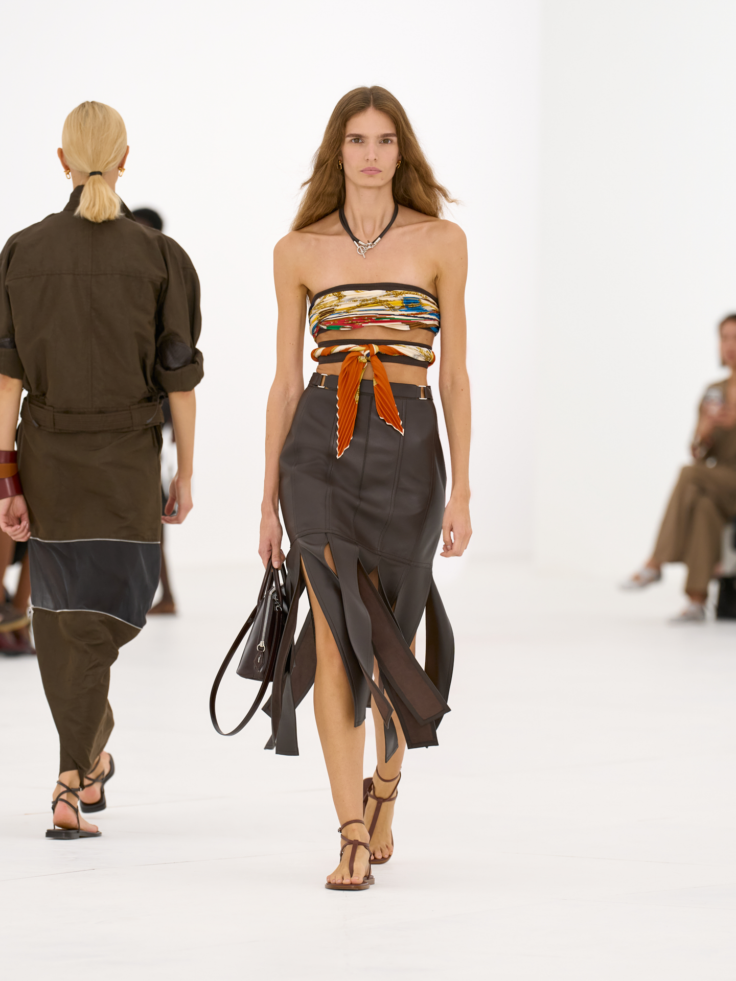 Top efecto pañuelo y falda de cuero marrón en el desfile Hermès primavera-verano 2027