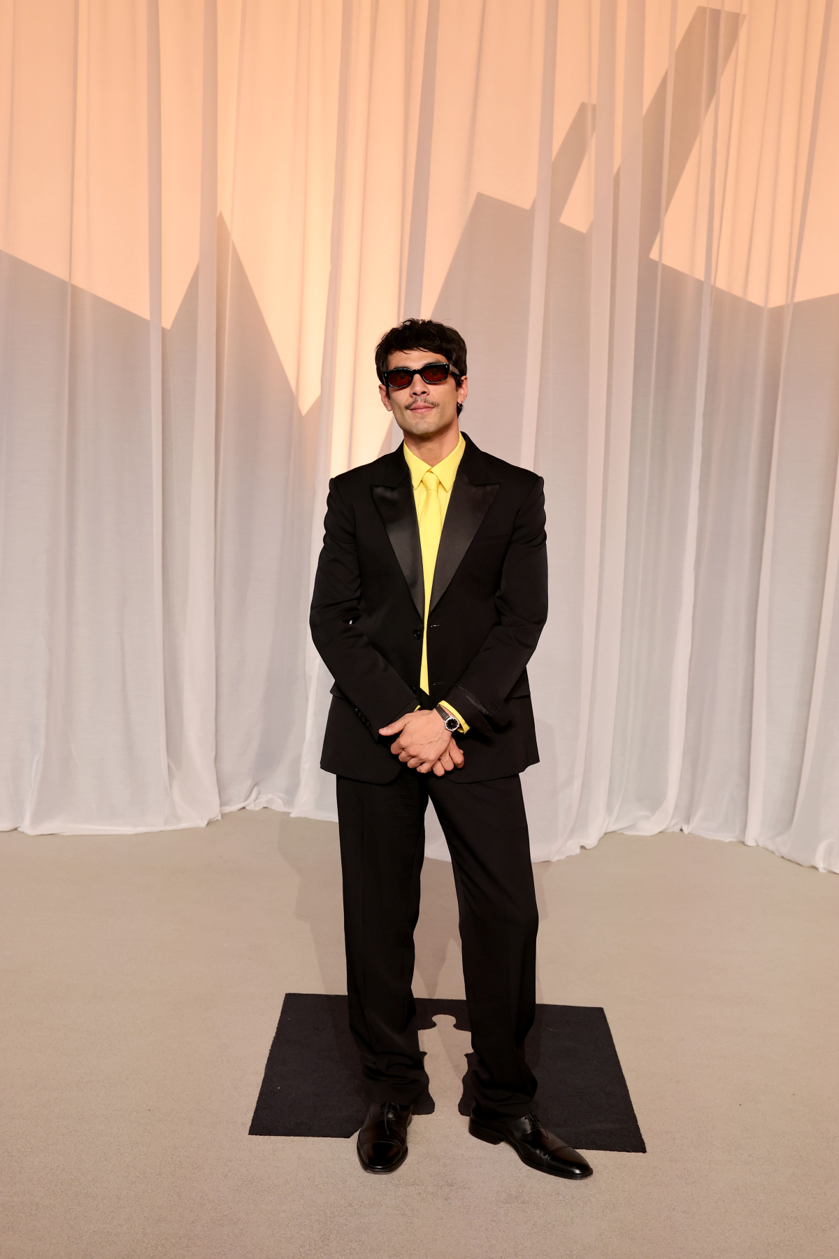 Diego Calva con esmoquin de LOEWE de chaqueta de botonadura sencilla, camisa amarilla, corbata de seda amarilla a juego y zapatos Crown Oxford en la Academy Museum Gala 2026