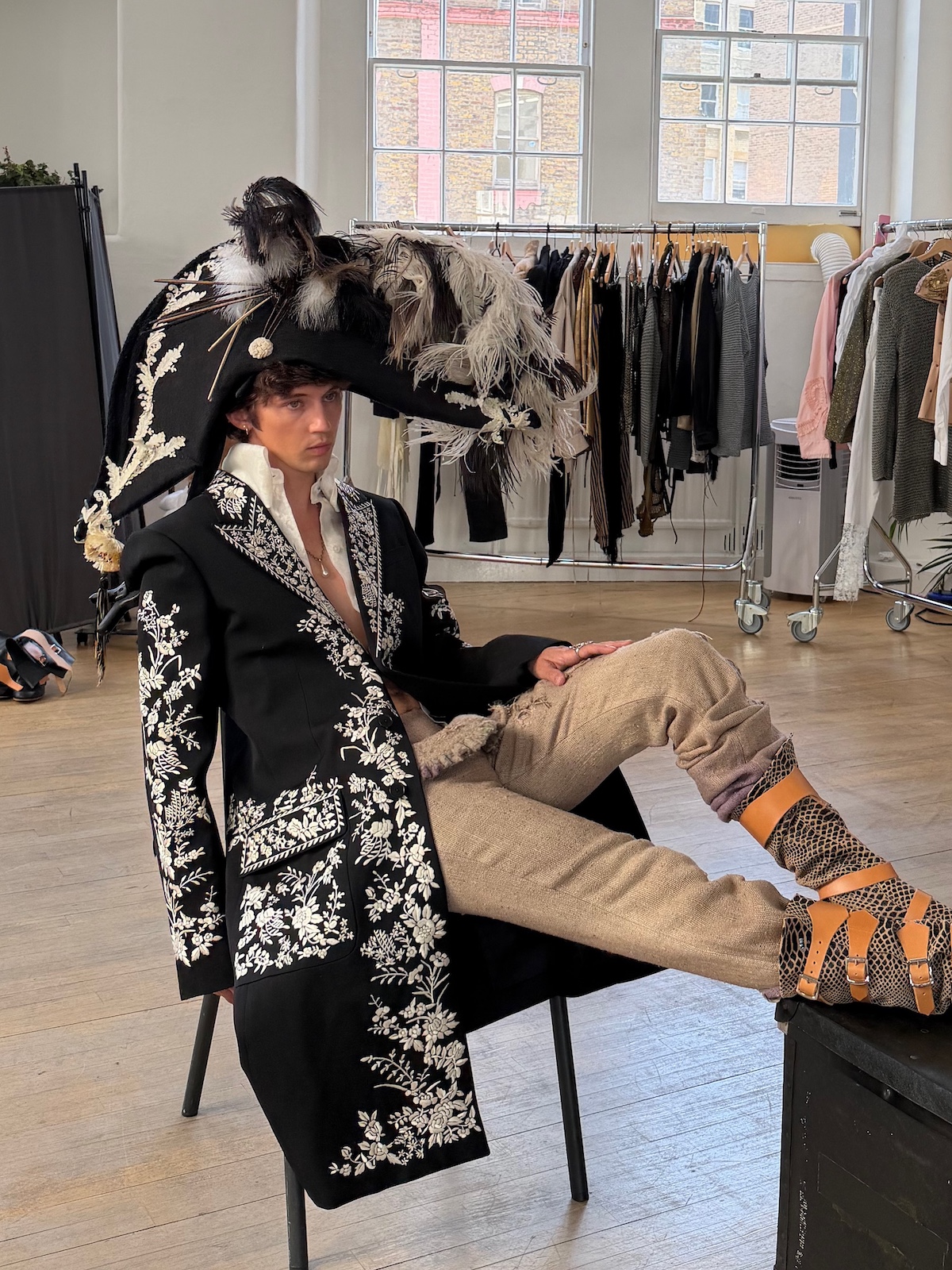 Troye Sivan luce un espectacular estilismo con abrigo bordado y sombrero de plumas, reflejo de su particular universo estético y su estrecha relación con la moda. Imagen: @troyesivan