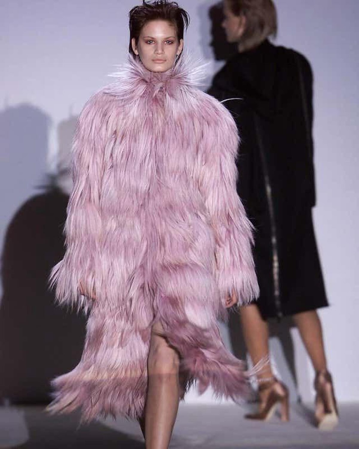 La imagen muestra un abrigo largo de pelo de cabra (Kidassia) de color rosa polvoso, perteneciente a la colección Gucci Otoño/Invierno 2001 diseñada por Tom Ford.