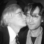 Andy Warhol dándole un beso en la mejilla al músico John Lennon