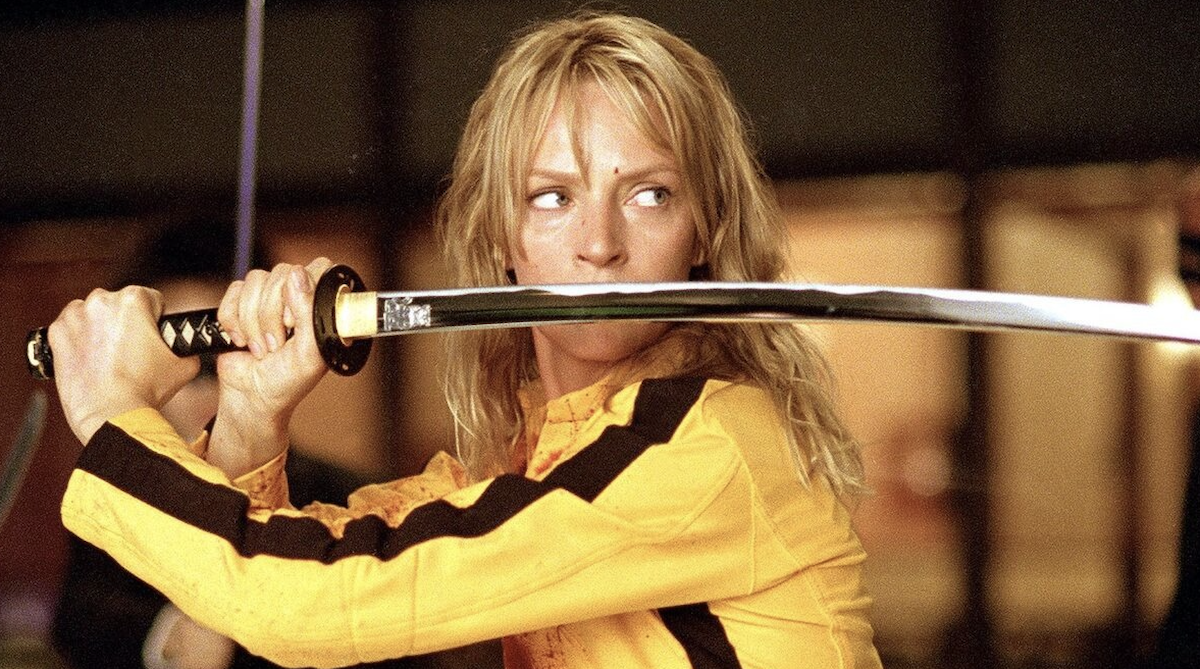 Uma Thurman en el papel de «La Novia» (Beatrix Kiddo) sosteniendo una katana japonesa frente a su rostro en la película Kill Bill: Volumen 1 (2003), dirigida por Quentin Tarantino