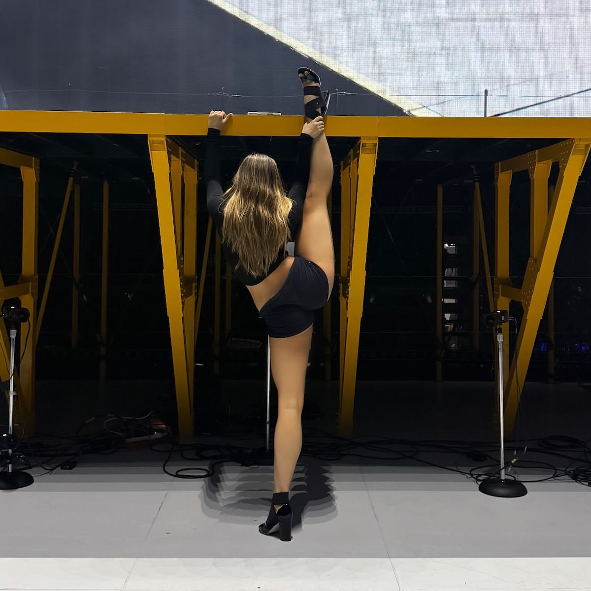 La artista realizando un estiramiento o postura de flexibilidad en un escenario