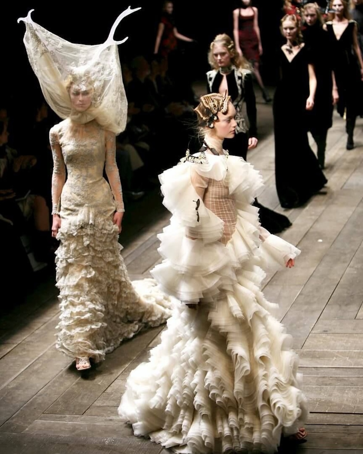 Raquel Zimmermann desfilando en la pasarela de Alexander McQueen con un vestido de tul y encaje de color crema acompañado de un tocado con astas de res del histórico desfile de la colección Otoño/Invierno 2006 